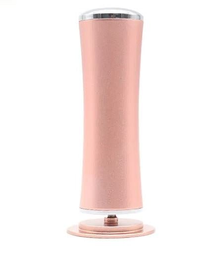 Rose gold electric foot file standing upright, front view
