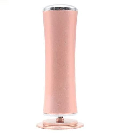 Rose gold electric foot file standing upright, front view